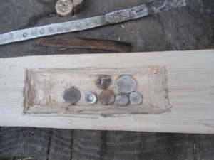 Geprägte Münzen und Rohlinge liegen in einer selbstgefertigten Holztruhe